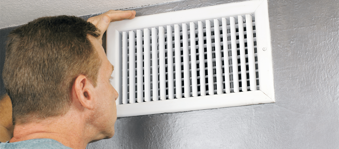 a man looking at an HVAC vent to see if it in need of HVAC Repair