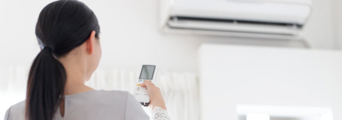 Woman turning on a ductless air conditioner