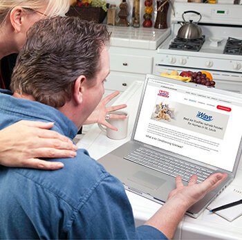 Couple In Kitchen Using Laptop to Research Crystal Heating & Cooling iWave
