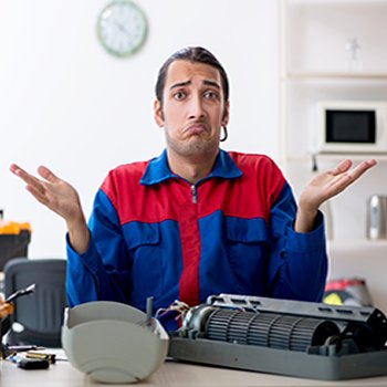 The young repairman repairing air-conditioner at warranty center